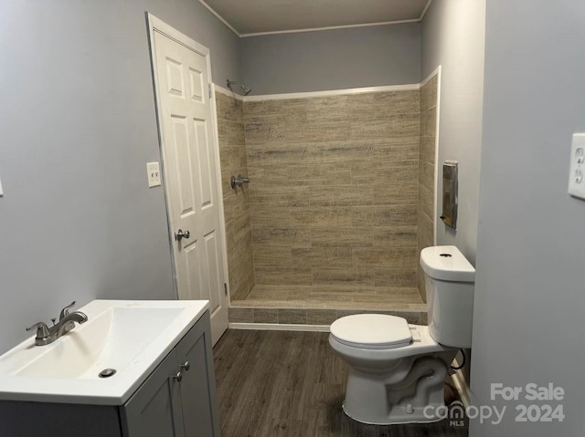 full bathroom featuring toilet, a stall shower, wood finished floors, and vanity