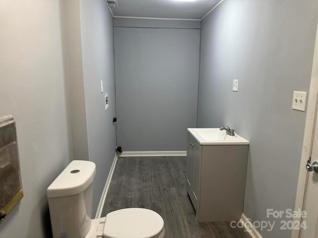 bathroom featuring toilet, wood finished floors, visible vents, vanity, and baseboards