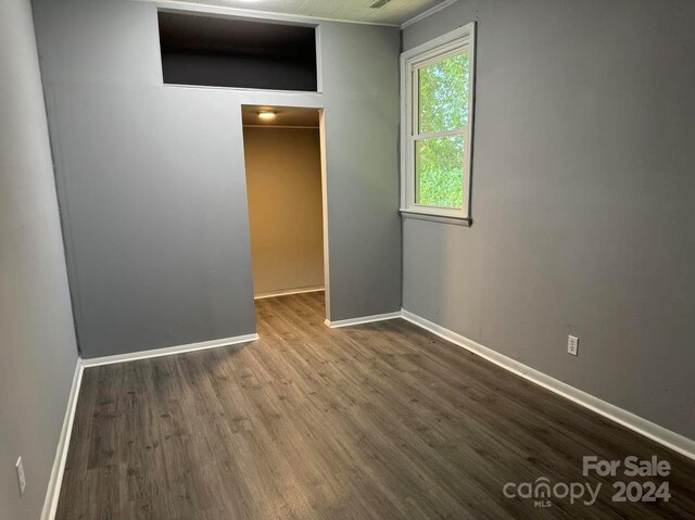 empty room featuring baseboards and wood finished floors