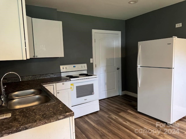 kitchen featuring dark countertops, white appliances, white cabinetry, and a sink