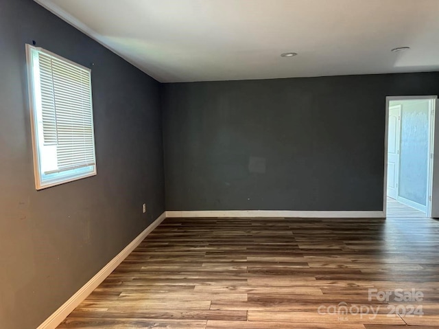 unfurnished room featuring wood finished floors and baseboards