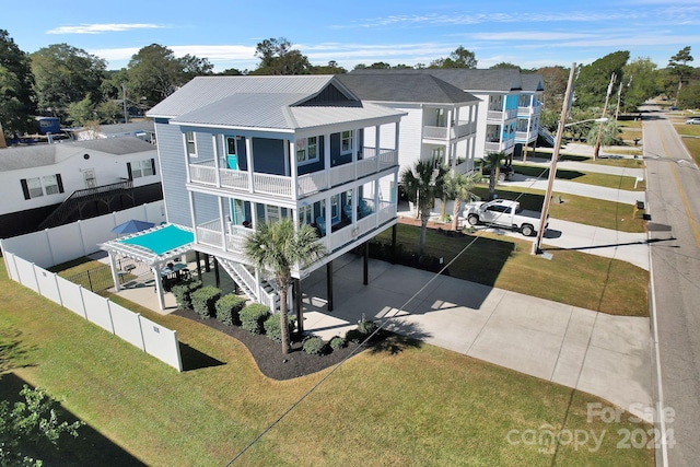 rear view of house featuring a yard and a balcony