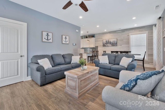 living room featuring ceiling fan and light hardwood / wood-style flooring