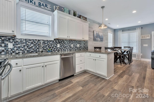 kitchen featuring hardwood / wood-style floors, white cabinets, decorative light fixtures, and stainless steel appliances