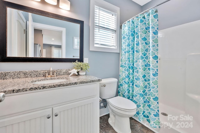 bathroom featuring vanity, a shower with shower curtain, and toilet