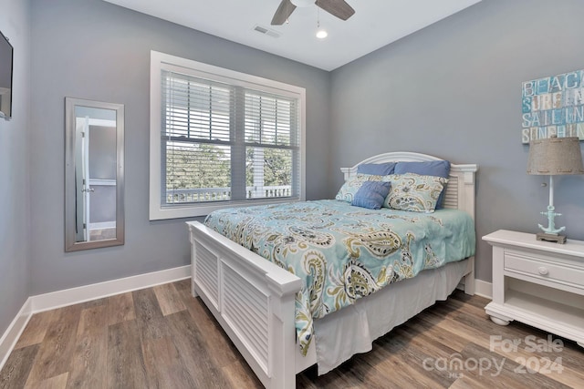 bedroom with dark hardwood / wood-style floors and ceiling fan