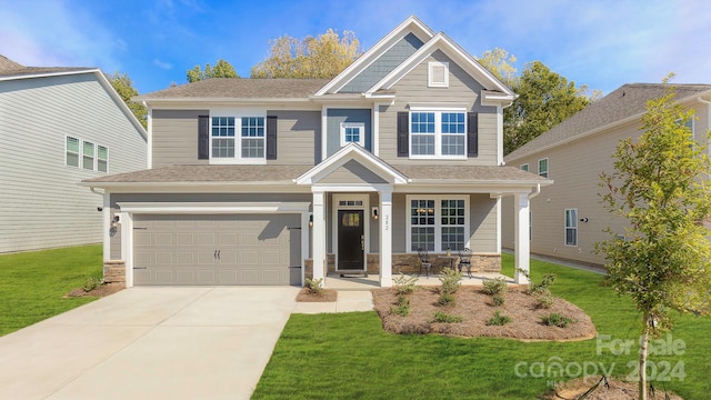 craftsman house with a garage and a front lawn