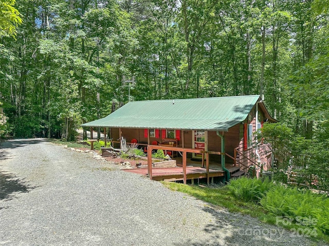 78 Smiling Fox Trl, Brevard, NC 28712 - view of front of house with a porch, a wooded view, and a metal roof