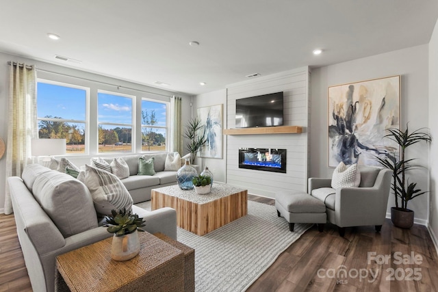 living room with dark hardwood / wood-style floors and a large fireplace