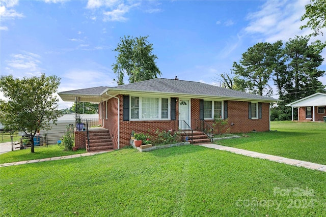 ranch-style house featuring roof with shingles, a front lawn, and brick siding