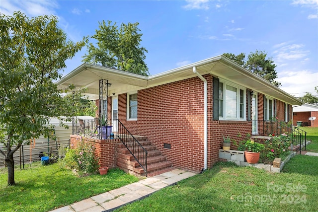 ranch-style house featuring a front yard and brick siding