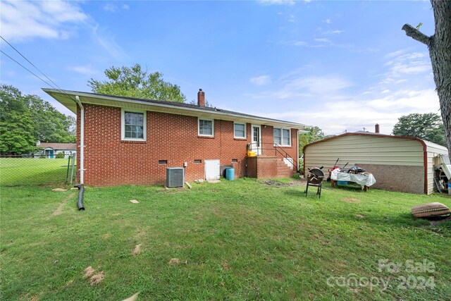 back of property with cooling unit and a yard