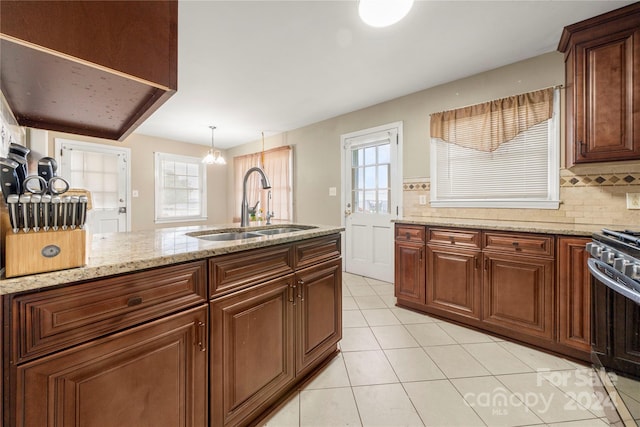 kitchen with sink, plenty of natural light, light tile patterned floors, and backsplash