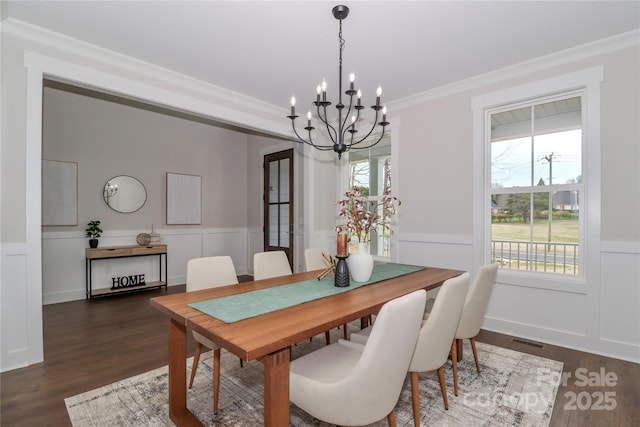 dining area featuring visible vents, dark wood-type flooring, wainscoting, and crown molding