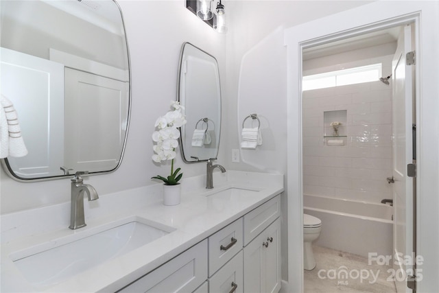 bathroom with double vanity, tile patterned flooring, toilet, and a sink