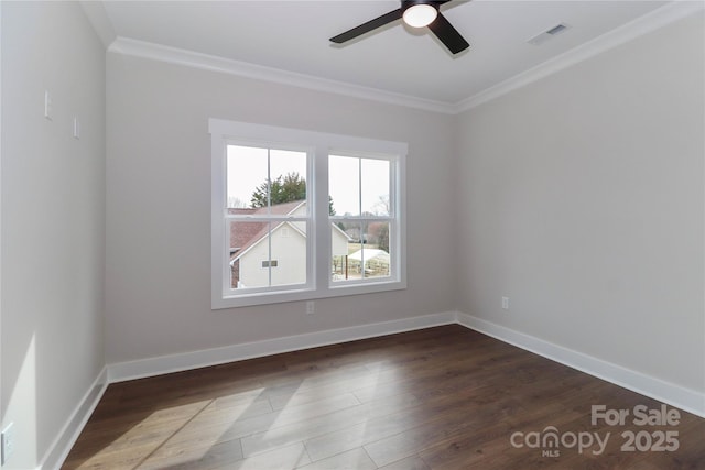 spare room featuring visible vents, ornamental molding, wood finished floors, baseboards, and ceiling fan