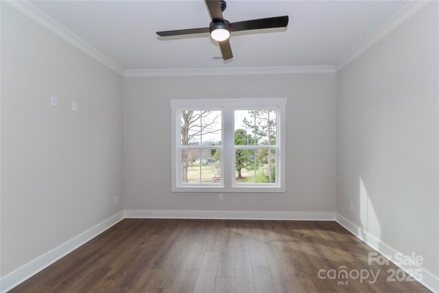 spare room featuring baseboards, dark wood-type flooring, ornamental molding, and a ceiling fan