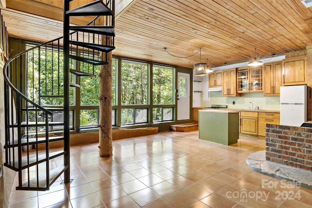 kitchen featuring decorative light fixtures, sink, wood ceiling, light tile patterned flooring, and white refrigerator