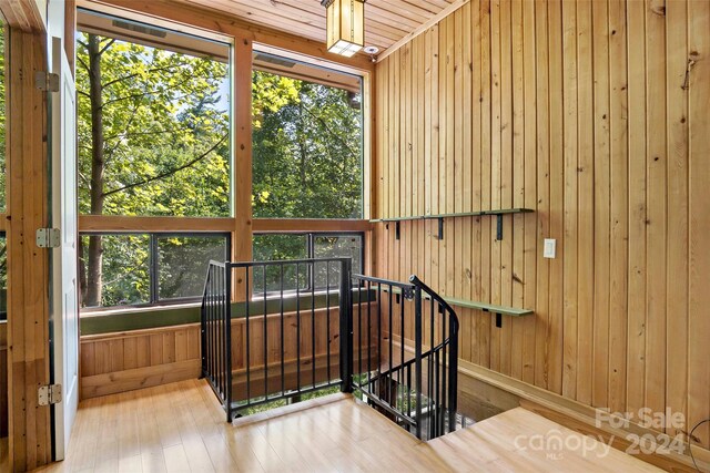 stairway with wooden walls and wood-type flooring