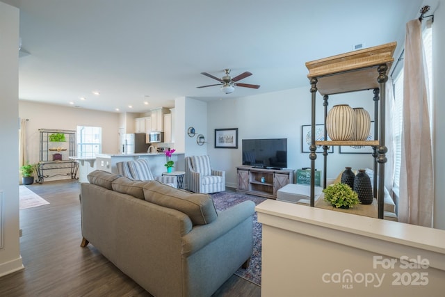 living room with ceiling fan and dark hardwood / wood-style flooring