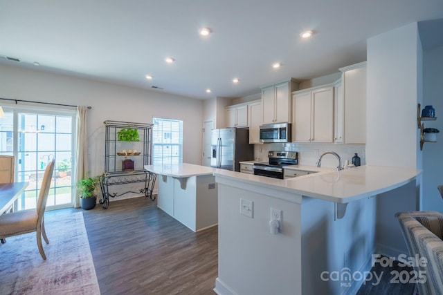 kitchen featuring a kitchen breakfast bar, a kitchen island, plenty of natural light, and stainless steel appliances