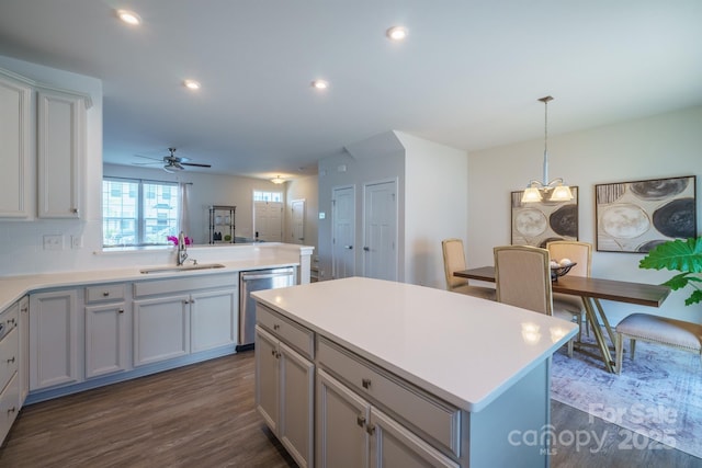 kitchen featuring ceiling fan with notable chandelier, sink, dishwasher, a center island, and gray cabinets