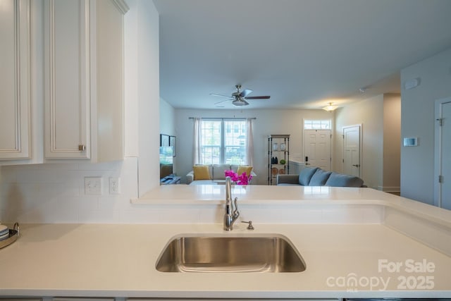 kitchen with backsplash, ceiling fan, and sink