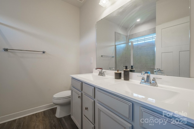 bathroom featuring vanity, toilet, wood-type flooring, and walk in shower