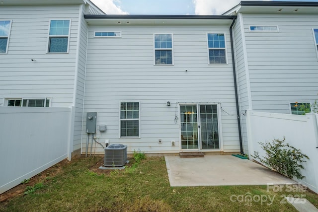 rear view of house featuring central AC unit, a patio, and a lawn