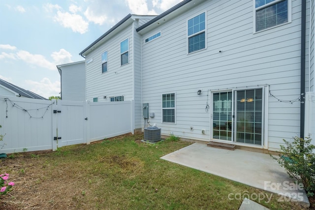 rear view of house with a lawn, a patio area, and central air condition unit