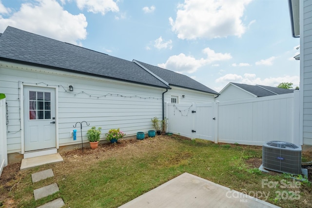 back of property with a lawn, central AC, and a patio