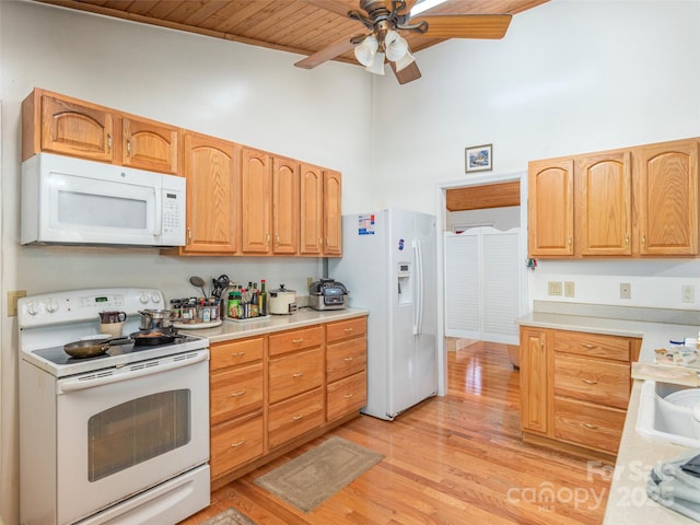 kitchen with white appliances, wooden ceiling, ceiling fan, light wood-type flooring, and a towering ceiling