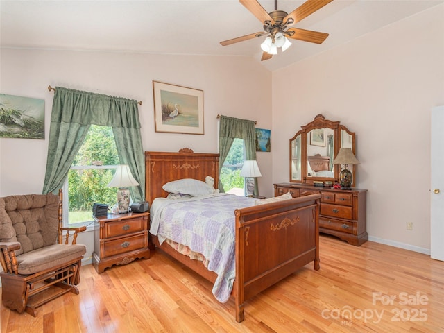 bedroom with ceiling fan, light hardwood / wood-style flooring, and vaulted ceiling