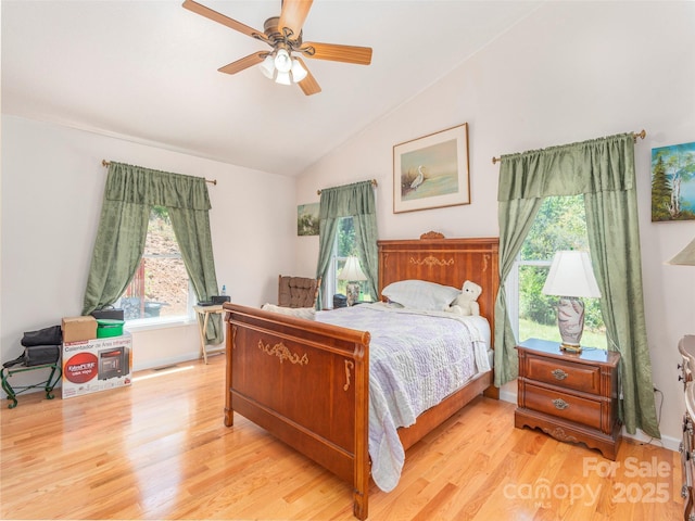 bedroom featuring ceiling fan, light hardwood / wood-style floors, and vaulted ceiling