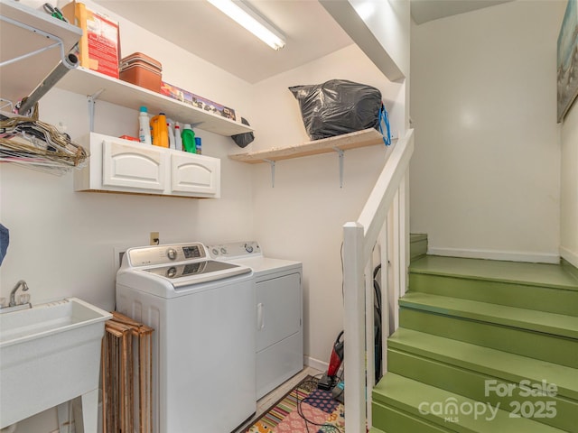 laundry room featuring separate washer and dryer, sink, and cabinets