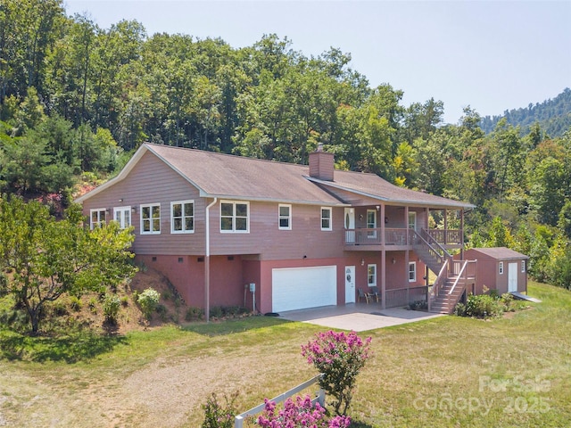 back of house with a garage and a yard