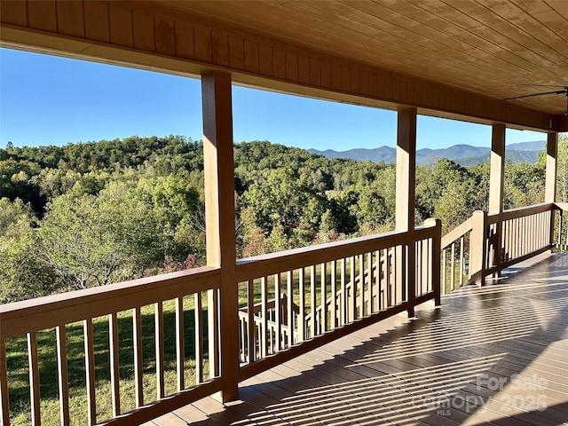 wooden terrace featuring a mountain view and ceiling fan