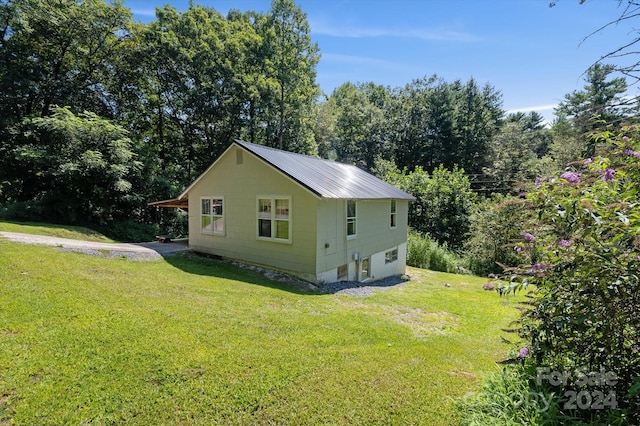 view of side of home with a yard