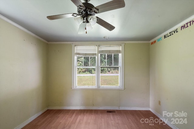 empty room featuring crown molding, hardwood / wood-style flooring, and ceiling fan