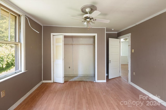 unfurnished bedroom with light wood-type flooring, a closet, ceiling fan, and crown molding