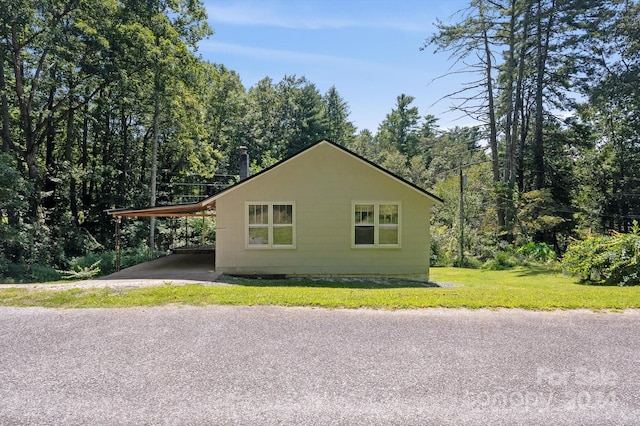 view of side of property with a lawn and a carport