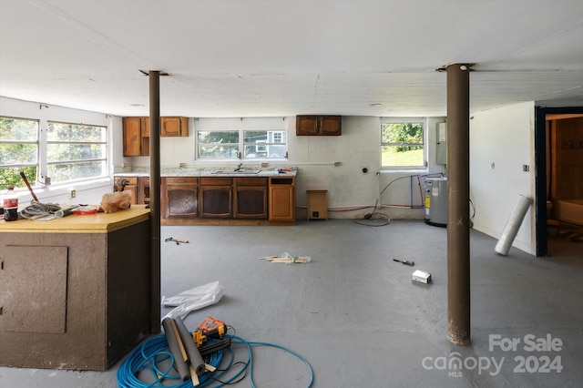 misc room with a wealth of natural light, electric water heater, and concrete flooring