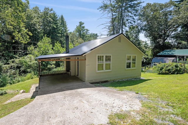 view of property exterior with a yard and a carport