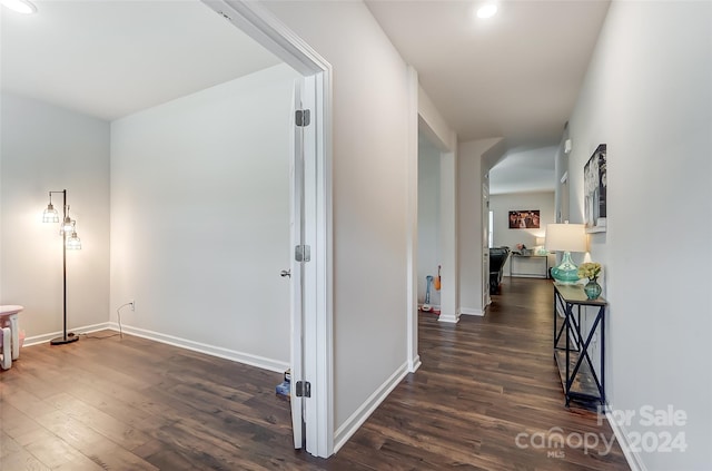 hallway with baseboards and dark wood-type flooring