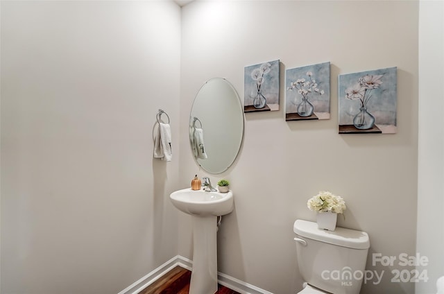 bathroom with toilet and baseboards