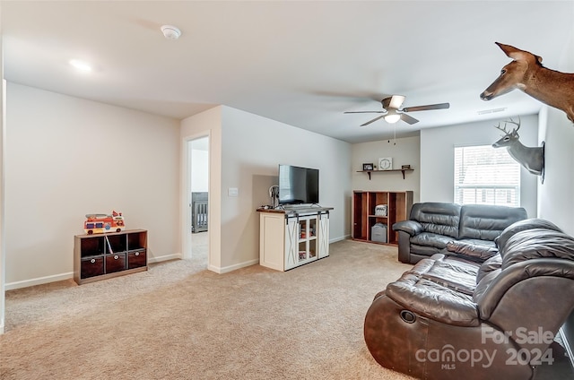 living room with a ceiling fan, light colored carpet, visible vents, and baseboards