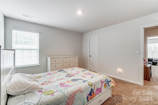 bedroom with light carpet, visible vents, and baseboards