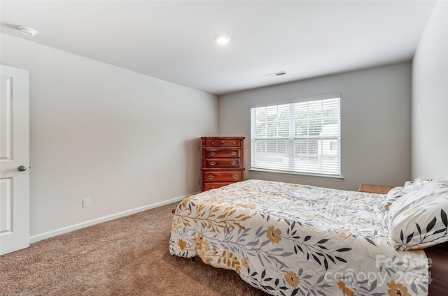 bedroom with carpet floors, visible vents, and baseboards