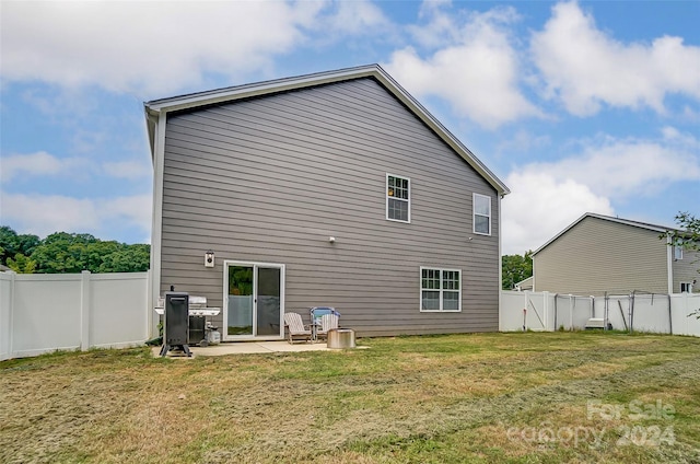 rear view of house featuring a lawn, a patio area, and a fenced backyard