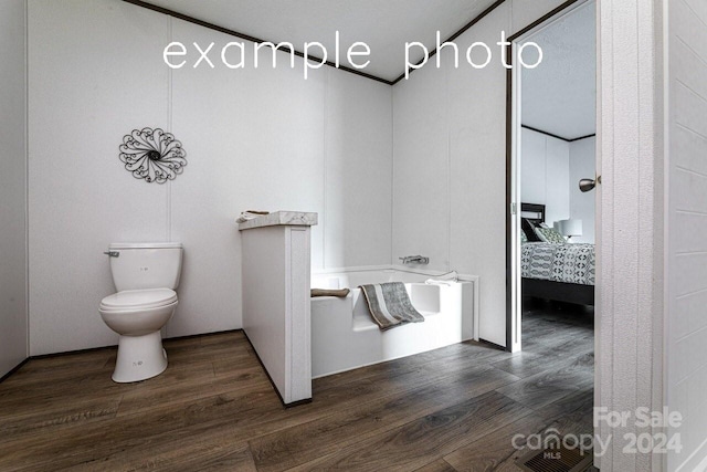 bathroom with a tub, toilet, a textured ceiling, and wood-type flooring